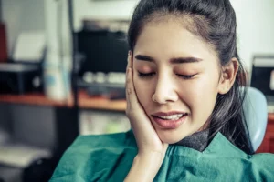 A woman experiencing toothache, an indicator of gum disease. Big Sky Family Dental provides expert care for all stages of gum disease to maintain oral health.