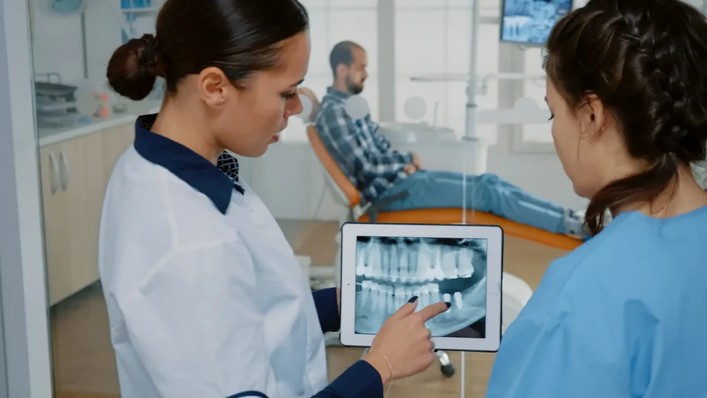 Dentist showing a dental X-ray on a tablet, discussing how to strengthen teeth and maintain oral health at Big Sky Family Dental.